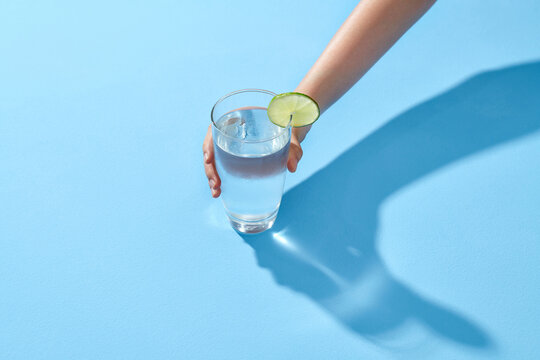 A hand holding a glass of water