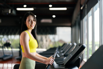 Fototapeta na wymiar Young Asian Woman Running on Treadmill - Fitness Gym Exercise