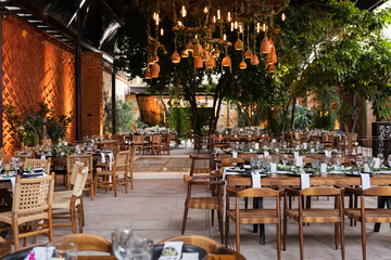 A wedding setup with wooden tables and chairs