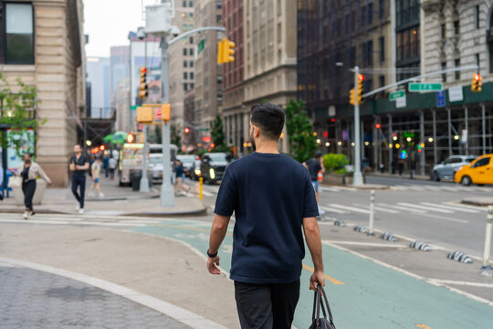 Bearded Boy Walking Holding A Bag On The Streets In The City.