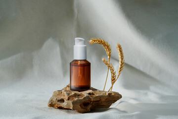 Skin serum bottle next to natural stone against bright