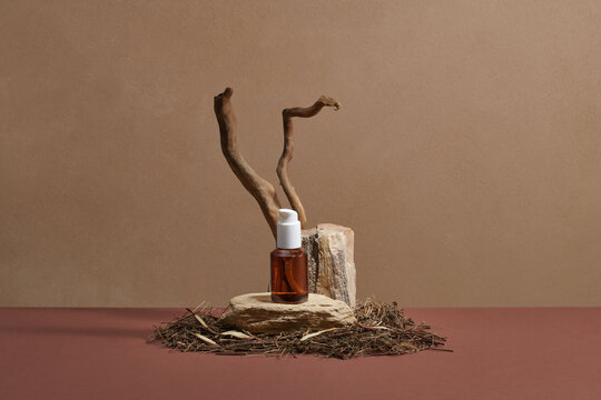 Essential oil bottle with dropper on dry tree branch