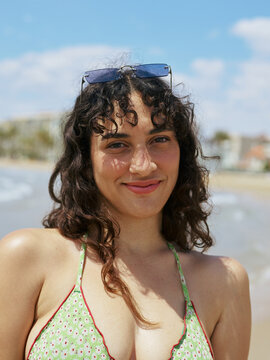 Real body woman in bikini and sunglasses at the sea shore        