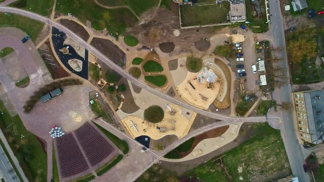 Aerial drone top down junction intersectional rural roads around agricultural fields geometrical shapes of autumn green grass and brown roof, autumnal architecture