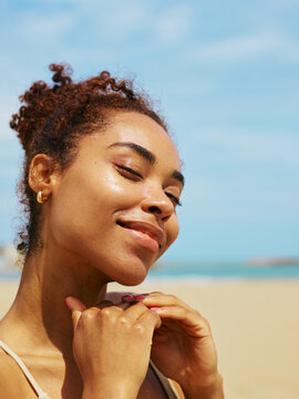 Happy radiant woman with just applied sunscreen at beach vacation     