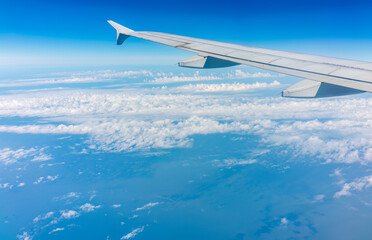 Obraz premium View from the airplane window at a beautiful cloudy sky and the airplane wing