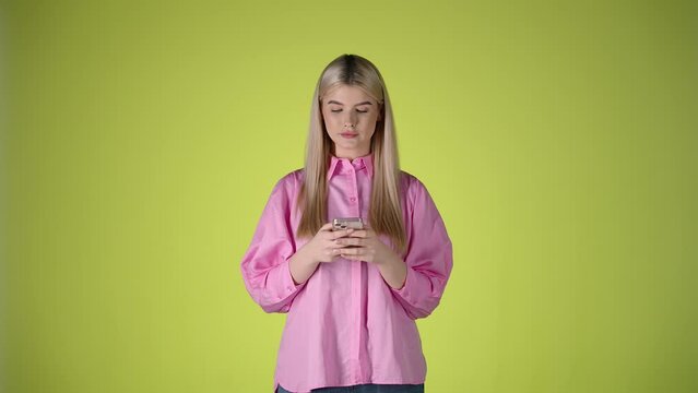 Millennial, Gen Z woman stares at Smartphone, typing and smiling, studio shot