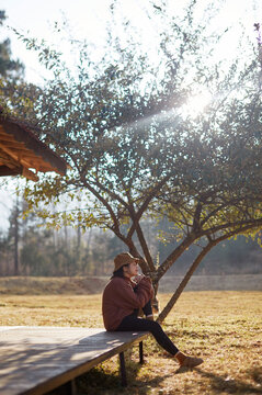 Asian woman,under the tree in the yard of the homestay on the journey