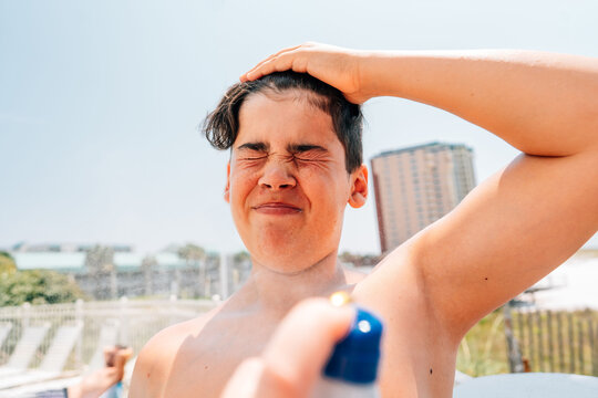 Teenager getting sunscreen applied to face. 