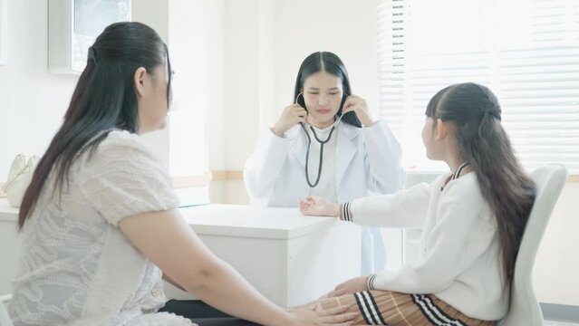 Mother and daughter at the doctor's office. doctor using sphygmomanometer with stethoscope checking blood pressure to patient in the modern hospital in clinic