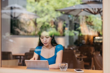 Woman in a cafe using a digital tablet