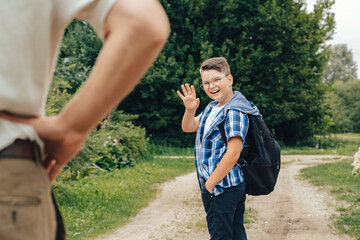Boy waving goodbye to dad. Back to school.