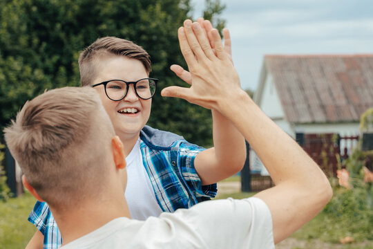 Happy Teenage Boy Sharing a High-Five with Dad. Back to School