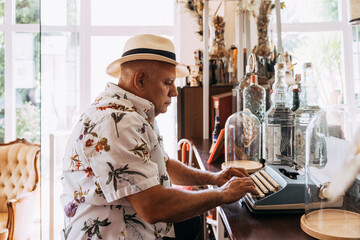 Old cuban man typing on vintage typewriter
