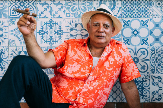 Senior cuban man in tropical outfit smoking a cigar