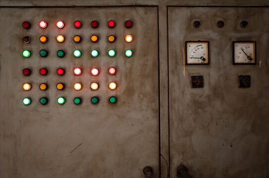 Dirty old and rustic electrical control panel with red, green and yellow lights