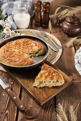 pie with cabbage and egg in a cut on a wooden background