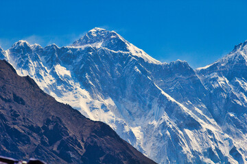 Everest Summit pyramid can be seen over the long Nuptse ridge line in this long range shot taken from Namche Bazaar,Nepal - obrazy, fototapety, plakaty