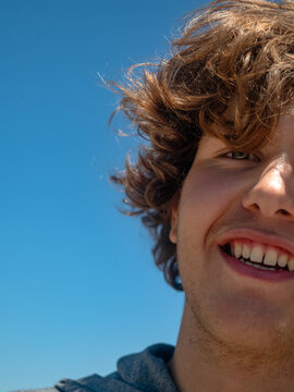 Young handsome guy with long hair smiling 
