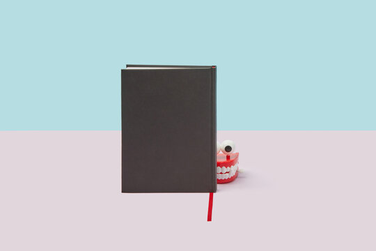 Jaws with eyes peeking out from behind book.