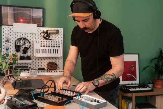Musician With Headphones Playing Music On Synthesizers 