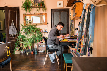 Male painter drawing abstract paintings using oil pastels