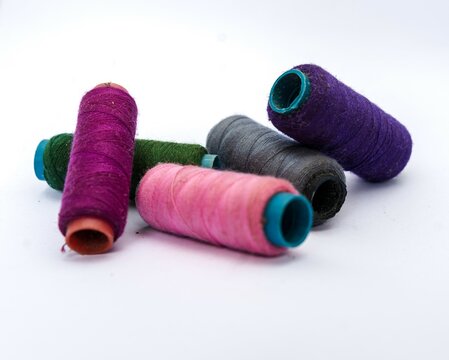 Pile of colorful sewing threads on isolated white background.Colored yarns used by factories in the clothing industry.