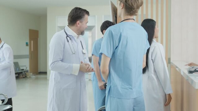 Multicultural doctors and nurses discussing in hospital lobby, symbolizing professional teamwork, healthcare collaboration, and modern medical environment with patient support service.