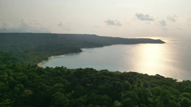 Aerial view of the green coastline with stunning beaches from ilha do principe (prince island) with the sunset reflected at sea. Sao Tome,Africa.
Backwards drone shot