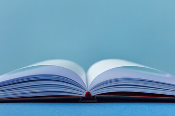 Close-up of open notebook on blue background.