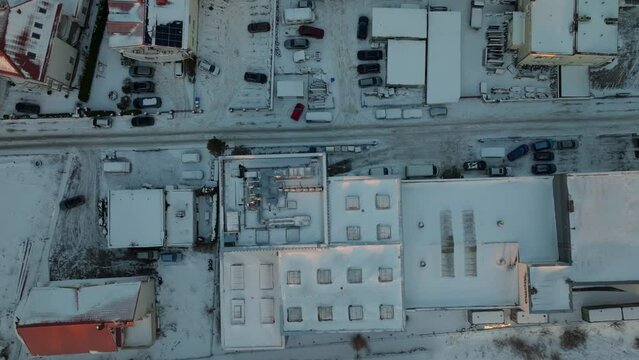 Snow covered homes and Buildings in suburb of polish city in winter. Aerial top down flyover. Parking cars in poor residential area.