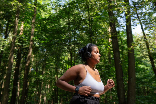 Plus Size Woman Running In The Forest At Summer