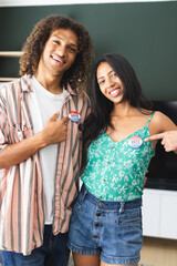 Young biracial couple proudly wear "I Voted" stickers, smiling broadly