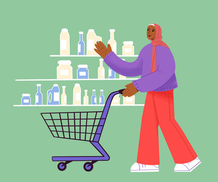 A woman in a headscarf pushes a full shopping cart