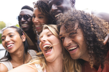 Diverse group of friends share a joyful moment, laughing together outdoors