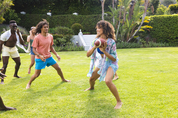 Obraz premium Diverse group of friends enjoy a game of football outdoors