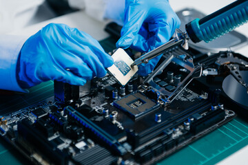 The technician is putting the CPU on the socket of the computer motherboard. electronic engineering electronic repair,