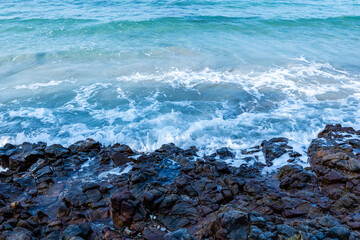 Ocean waves crash on the rocky beach.