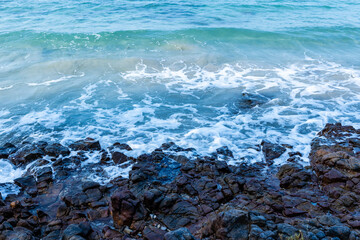 Ocean waves crash on the rocky beach.