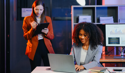 Two business workers talking on the smartphone and using laptop