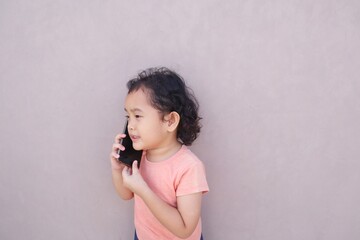The expression of a toddler girl talking on the phone.