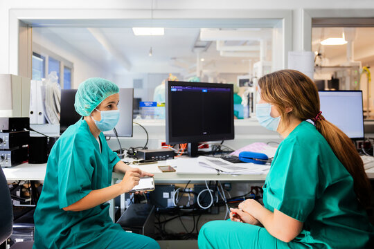 Focused women doctors sitting near desktop on table