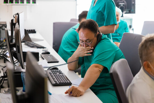 Analyst sitting at desktop table and speaking on phone