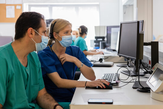 Man and woman doctors working on computer in hospital