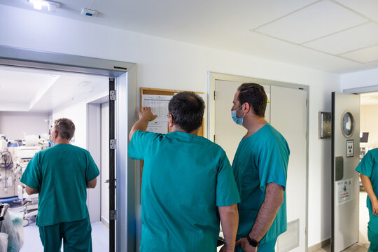 Anonymous Doctors Standing And Checking Notice Board