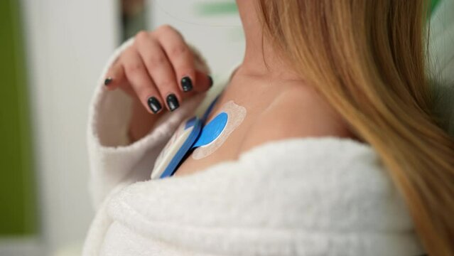 Detail cropped shot of unrecognizable young woman wearing holter monitor device for daily monitoring of an electrocardiogram 24 hour. Holter monitor daily monitoring of electrocardiogram.