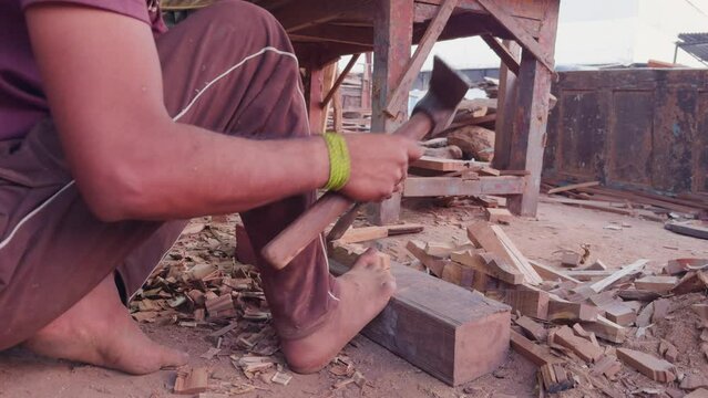 Artisan carving wood with tools on a dusty workshop floor showcasing traditional craftsmanship