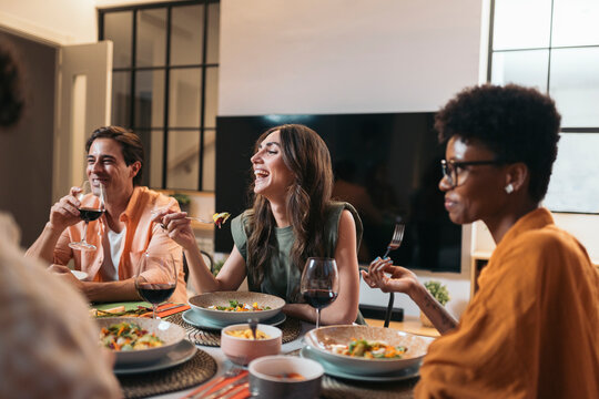 Diverse Friends Having Dinner at home While chatting