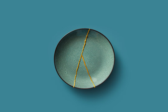 Green plate with gold kintsugi lines.