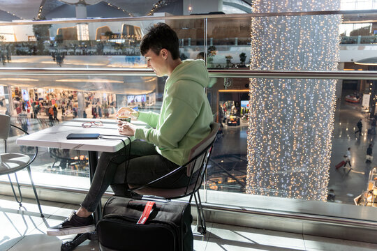Woman drinking coffee at airport.